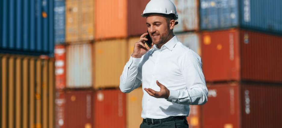 Supply Chain Manager telefoniert an einem Kontainer-Bahnhof